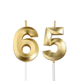 Bailym gold number 65 cake topper on a white fondant cake