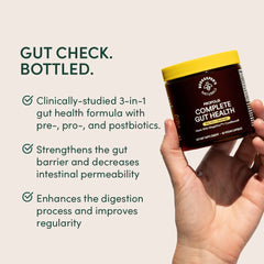 Beekeeper's Naturals Complete Gut Health capsules in hand for easy dosing.