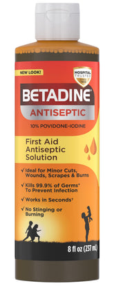Betadine antiseptic solution bottle pour for convenient wound protection.