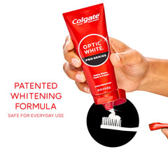 Hands brushing Colgate Optic White Pro Series toothpaste showing enamel-safe formula.
