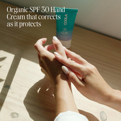 COOLA hand cream in use applying SPF 30 on skin