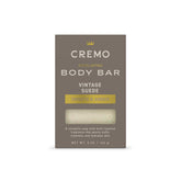 Cremo Vintage Suede Exfoliating Bar front close-up with textured lava rock.