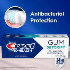 Crest Pro-Health Gum Detoxify toothpaste tube on toothbrush demonstrates easy daily use for deep gum-cleaning.