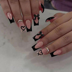 CTTHNBD coffin nails with black French tip and bow charms for a dramatic at-home manicure.