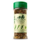 Flatiron Spice Hatch Green Chile Flakes bottle on counter for rich flavor enhancement.