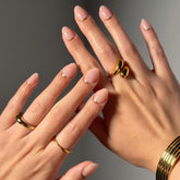 Glam Goals short oval nude nails with gold reversed French tip for a chic, salon look.