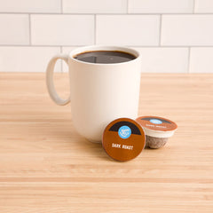 Close-up of Happy Belly Dark Roast pod highlighting 100% Arabica beans.