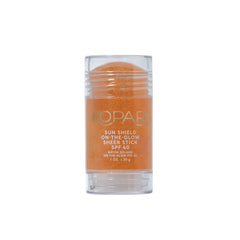 Kopari Sun Shield On-The-Glow stick applied to face for quick SPF protection
