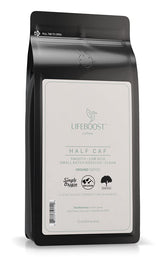 LIFEBOOST Half Caff ground coffee cup foreground delivering smooth morning energy.