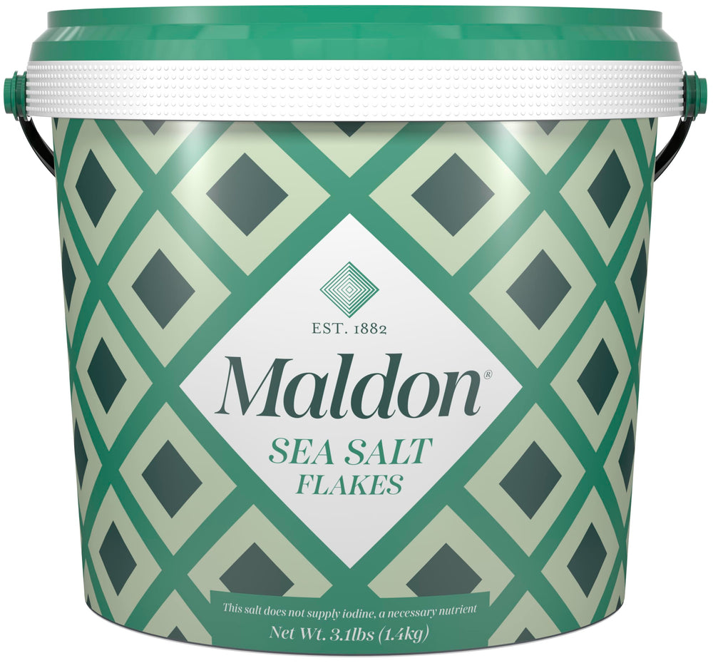 Maldon sea salt flakes tub close-up for gourmet seasoning and crisp texture.