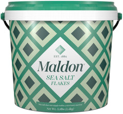 Maldon sea salt flakes tub close-up for gourmet seasoning and crisp texture.