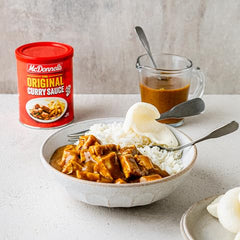 McDonnells curry sauce pour, ready to drizzle over dishes for flavor.