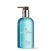 Molton Brown Coastal Cypress & Sea Fennel bottle pour for refreshing hand cleansing.