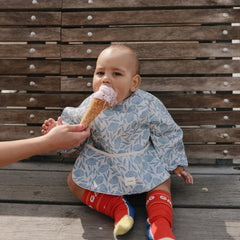 Mushie bib adjustable velcro closure demonstrates customizable neck fit for growing toddlers
