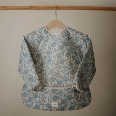 Mushie long sleeve bib blue flowers fabric closeup highlights water-resistant material