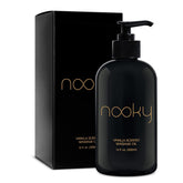 NOOKY Vanilla Massage Oil bottle on wood surface for smooth, hydrated skin.