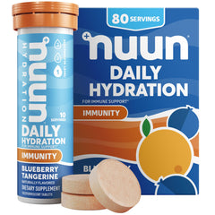 Nuun Immunity bottle poured into a glass of water with blueberry-tangerine flavor.