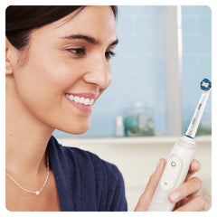 Close-up of Oral-B Precision Clean bristles reaching between teeth to remove plaque.