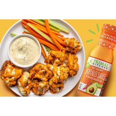 Primal Kitchen No Dairy Buffalo Sauce on wings for a spicy bite.