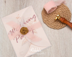 Ribbli blush pink ribbon used to wrap wedding invitations and bouquets.