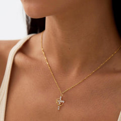 Robaice gold cross necklace worn on neck with an elegant crown pendant
