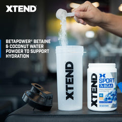 XTEND Sport Blue Raspberry Ice powder ready in a shaker for on-the-go hydration.