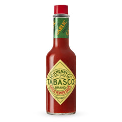 TABASCO Cayenne Garlic Pepper Sauce bottle on counter adds mild heat to meals.