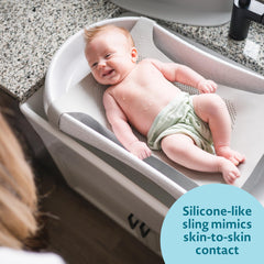 The First Years Rain Shower soft-feel sling cushions newborns for comfort.
