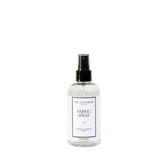 The Laundress Isle fabric spray bottle refreshing fabrics with a coastal scent.
