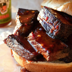 Pouring Tiger Sauce Original over grilled meats for a savory finish