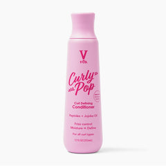 V&CO Curly Pop bottle closeup, hydrating formula for defined curls.
