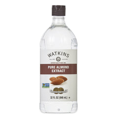Watkins Pure Almond Extract bottle pouring for baking flavor.