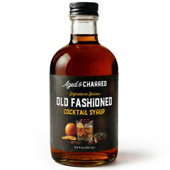 Aged & Charred Old Fashioned mix bottle being poured for a refined cocktail