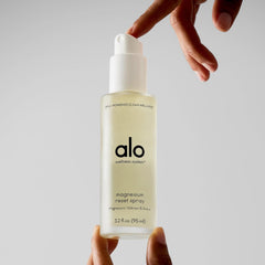 Alo magnesium oil spray mist on a pillow for restful sleep.