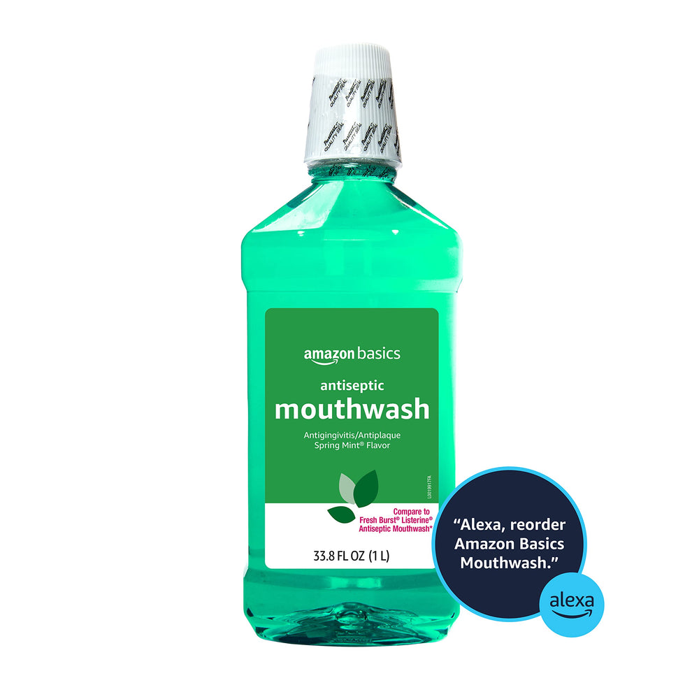 Amazon Basics antiseptic mouthwash being poured into a measuring cup for a daily rinse.