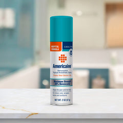 Hands dispensing Americaine benzocaine spray for convenient topical use.