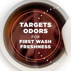 Arm & Hammer scent booster beads being poured into washing machine for fresh load.