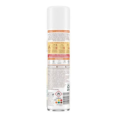 Batiste Tropical Dry Shampoo spray mist over hair roots for lift.