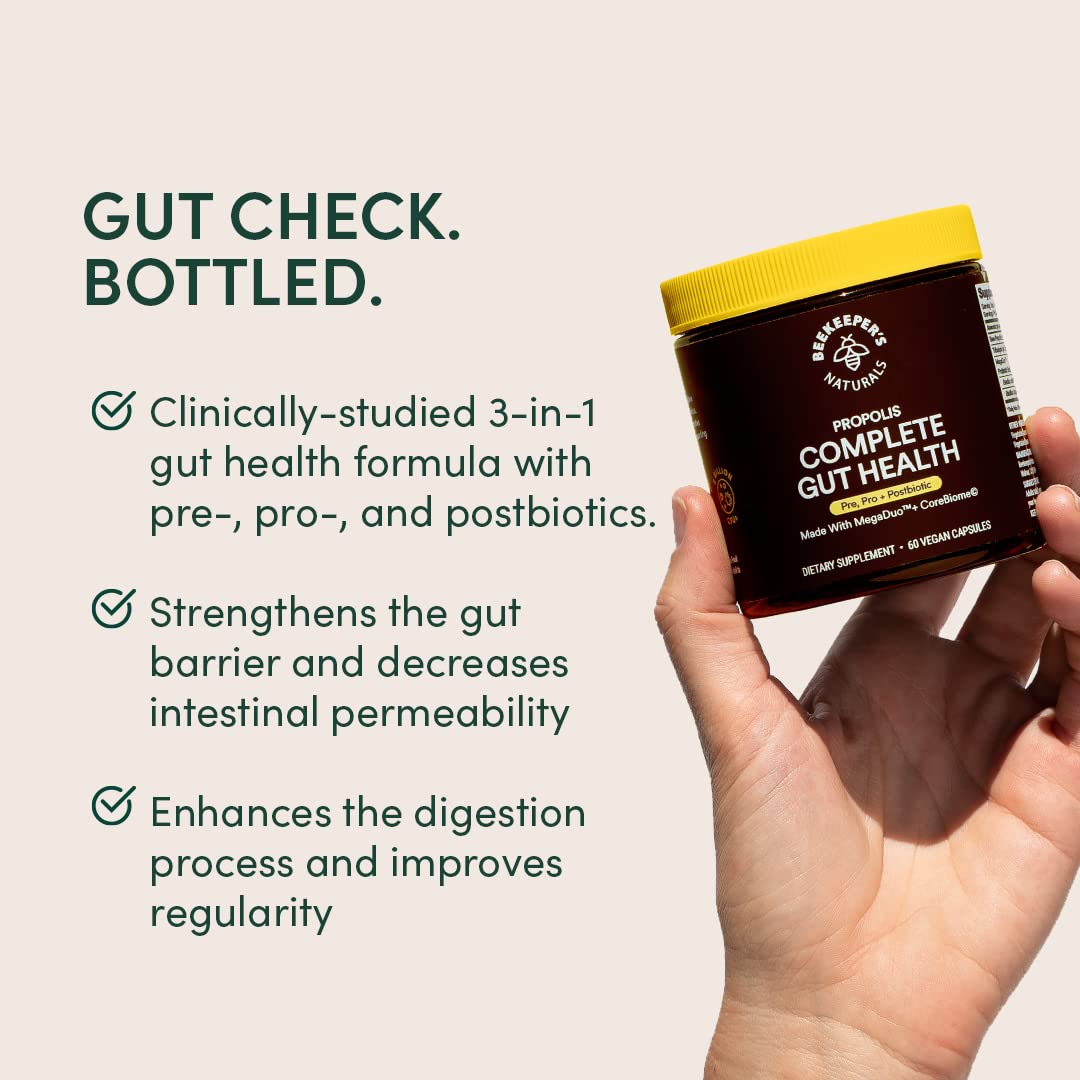 Beekeeper's Naturals Complete Gut Health capsules in hand for easy dosing.