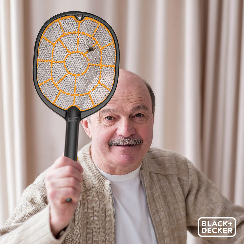 BLACK+DECKER bug zapper racket kitchen-use scenario near trash for odor-free cleanup.