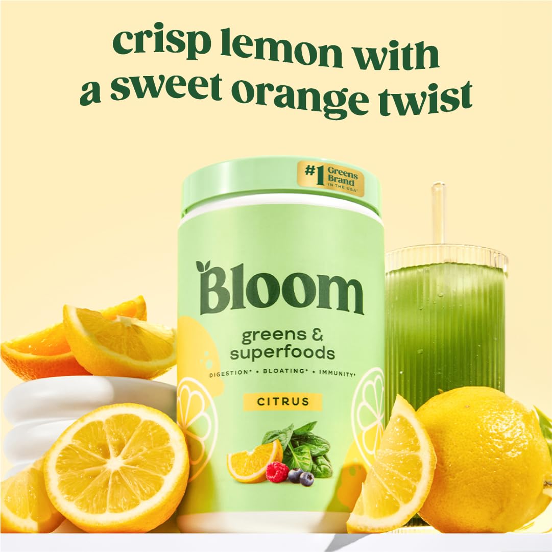 Scoop of Bloom Greens powder beside glass ready to mix into a smoothie