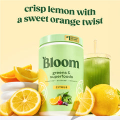 Scoop of Bloom Greens powder beside glass ready to mix into a smoothie