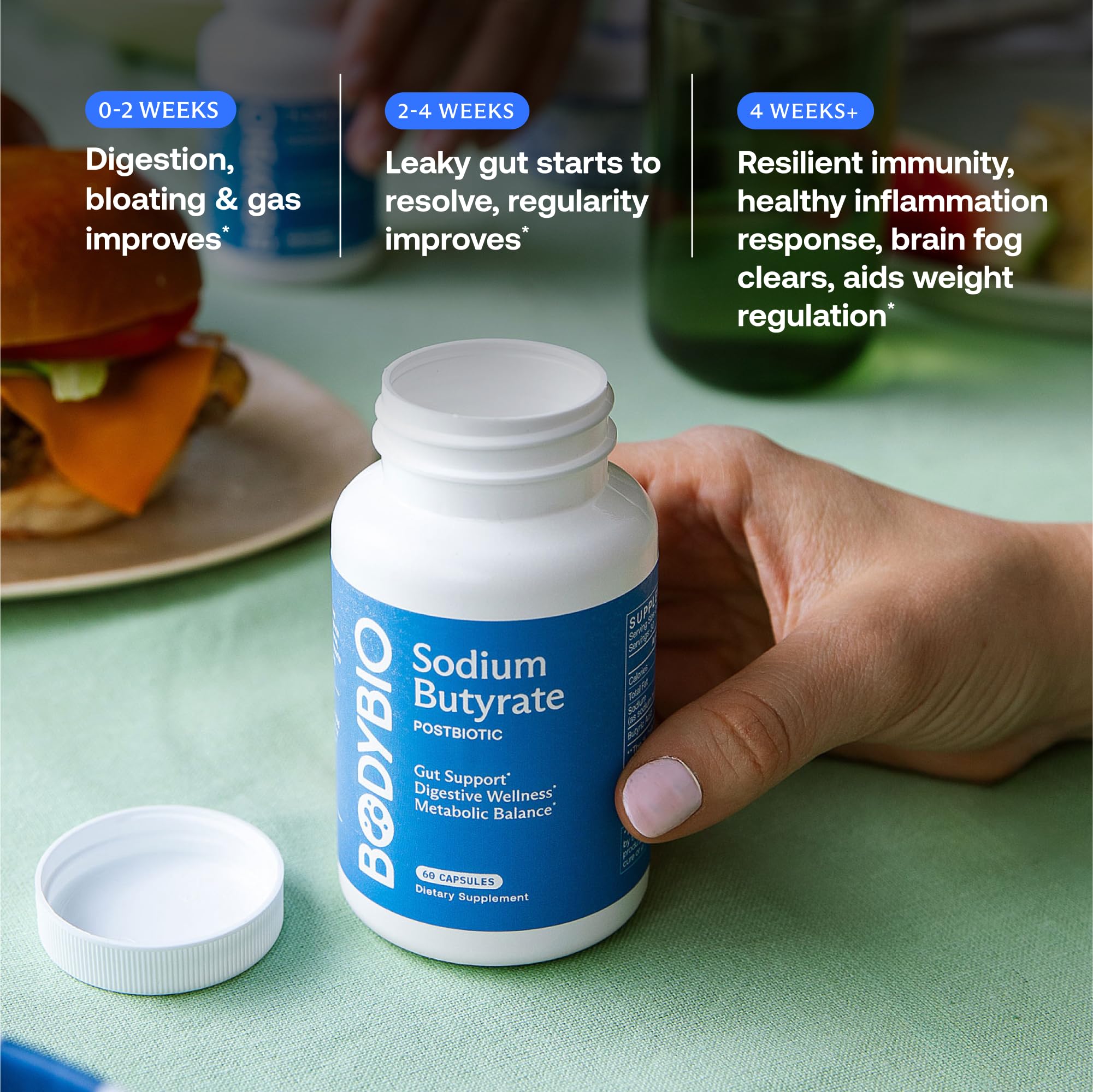 BodyBio Butyrate bottle beside glass of water for daily use