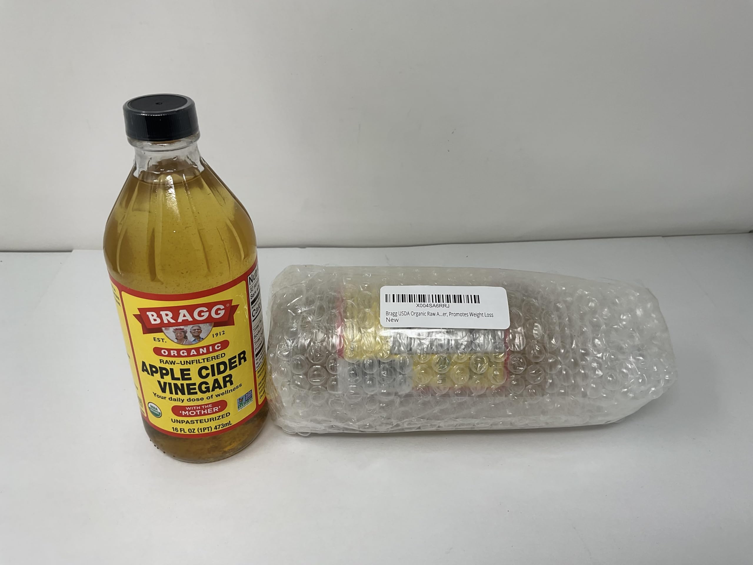 Bragg Apple Cider Vinegar bottle pour highlighting the Mother