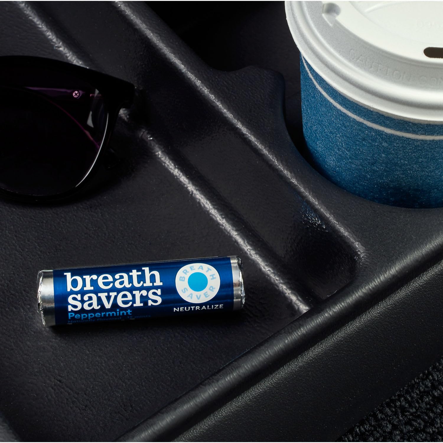 Breath Savers peppermint roll in car cup holder for on-the-go freshness.
