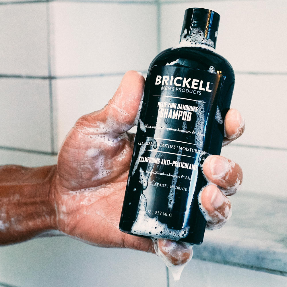 Brickell Men's Relieving Dandruff Shampoo label closeup, natural ingredients highlighted.
