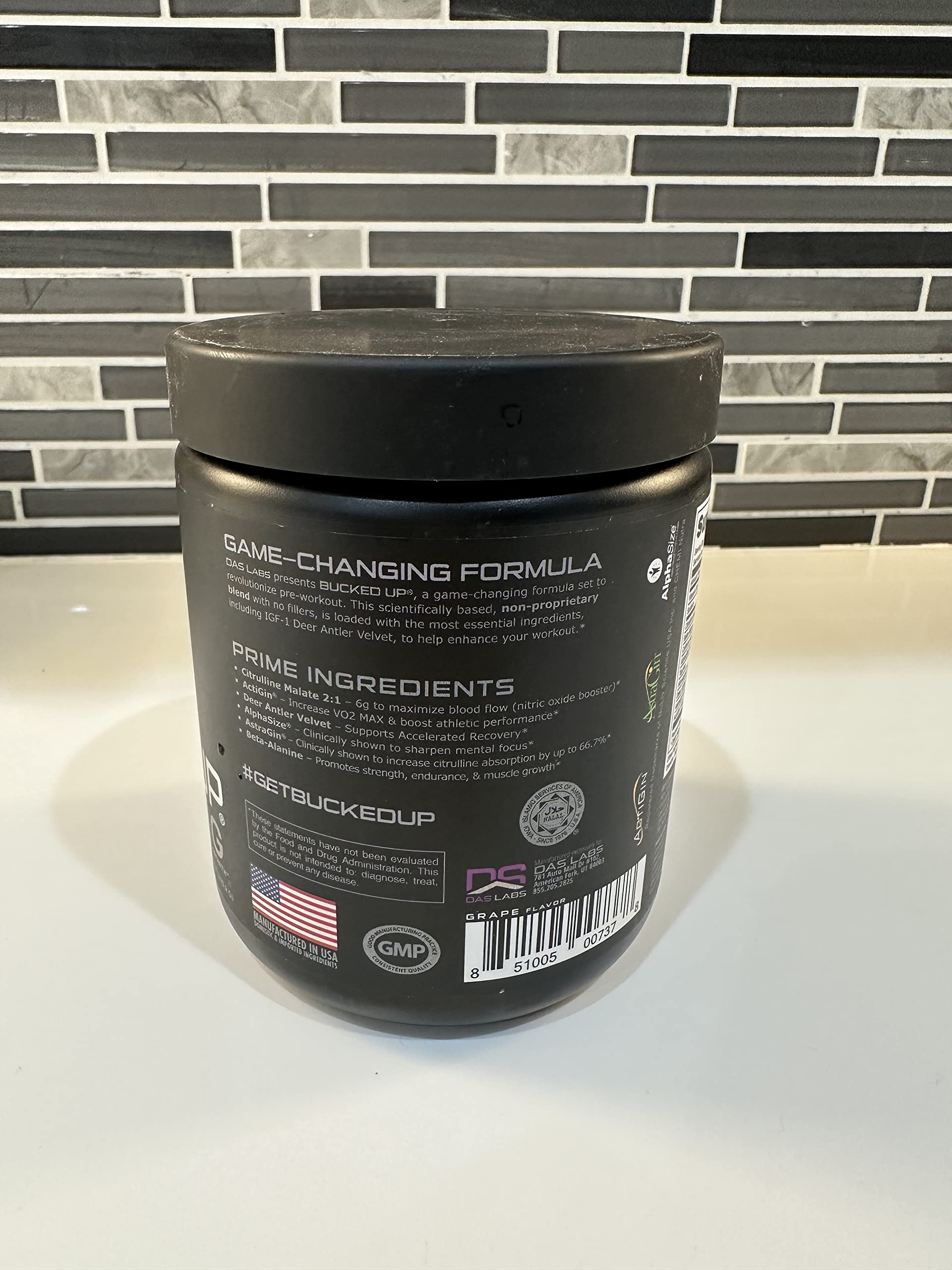 Bucked Up Pre Workout grape scoop beside the tub ready to measure.