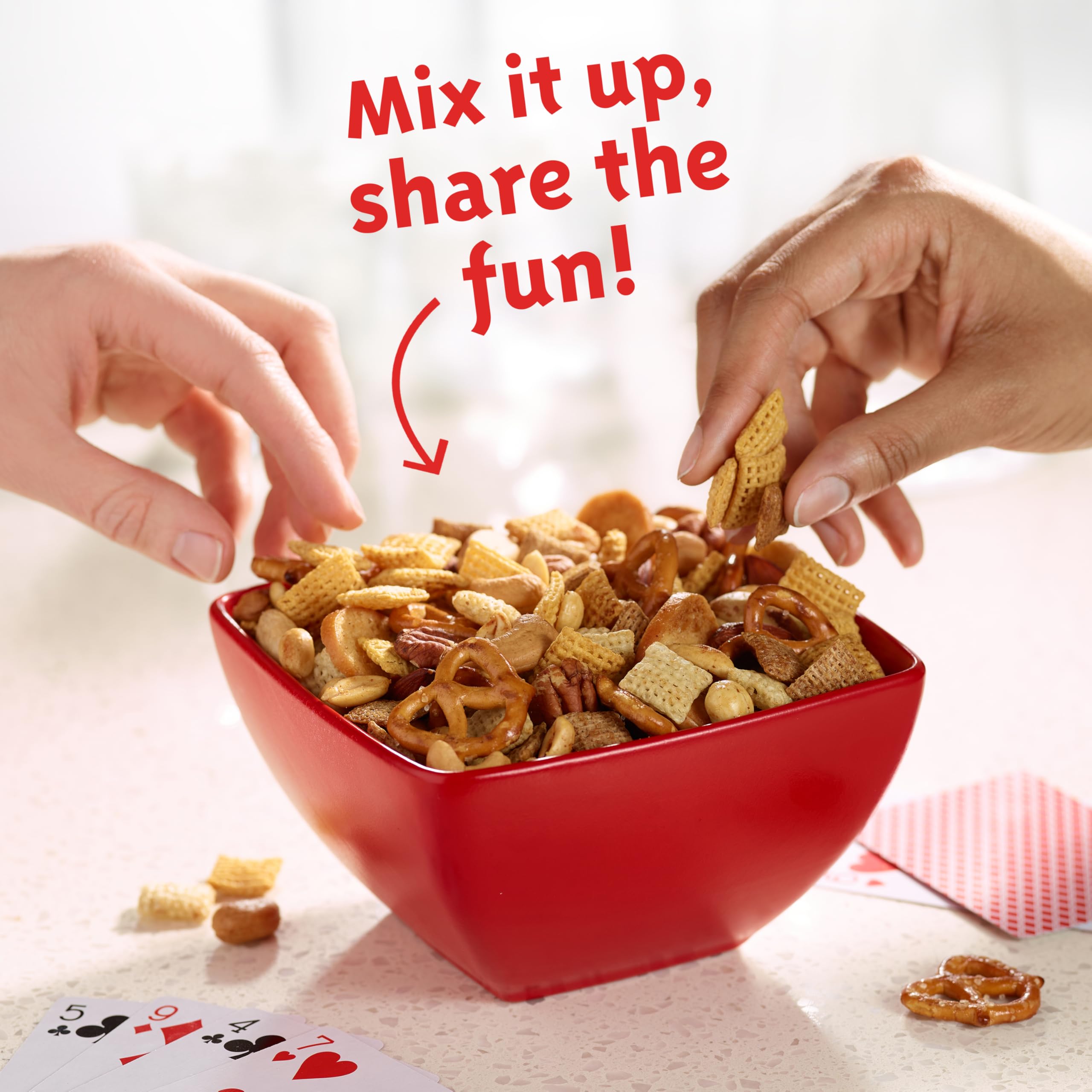 Chex cereal mixed with ingredients for a snack mix