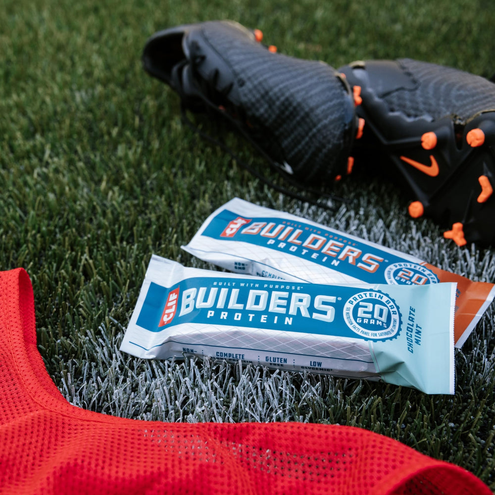 A cup of coffee beside CLIF BUILDERS bar hints caffeine synergy for focus.