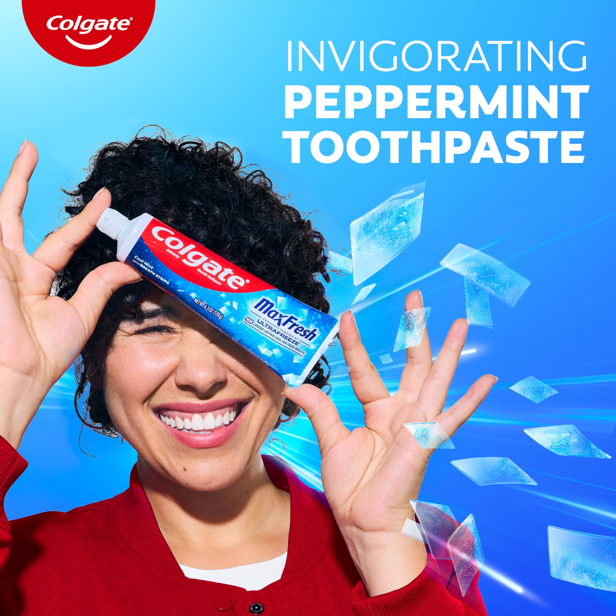 Person brushing teeth with Colgate MaxFresh in a bathroom setting.